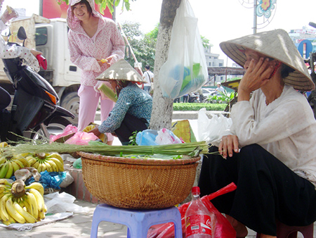 Một bà cụ bán hàng lặng lẽ bên hè phố
